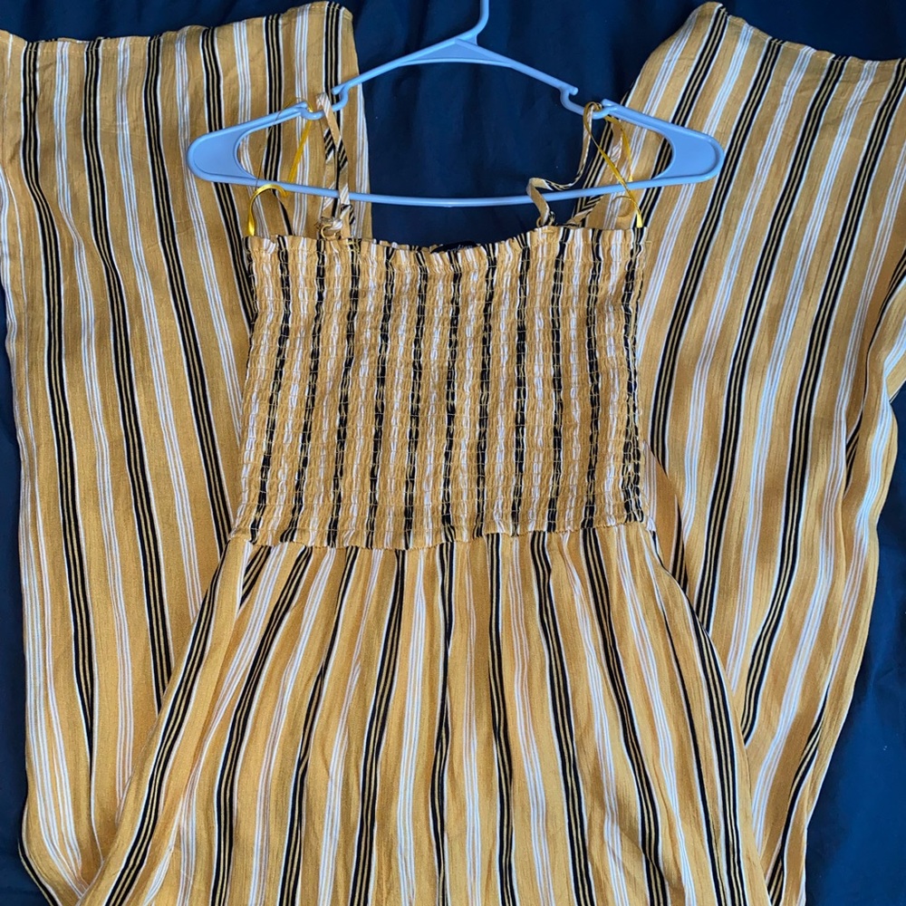 Flared black yellow and white striped jumpsuit .